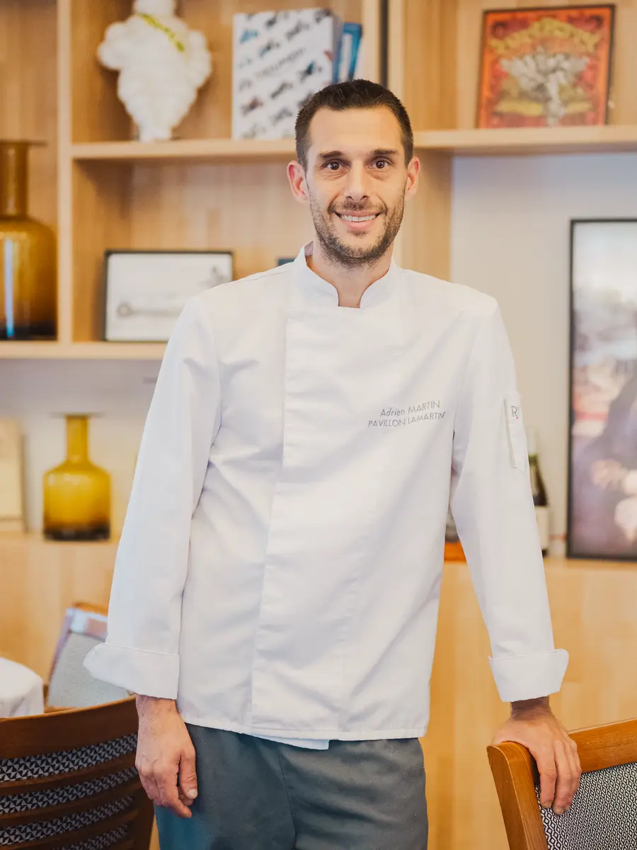 Adrien, le chef de cuisine, en veste blanche dans la salle du Pavillon